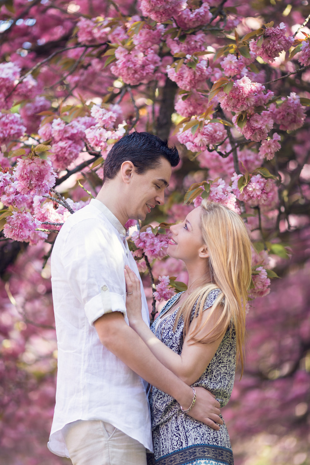 séance engagement romantique dans un parc avec les cerisiers en fleurs