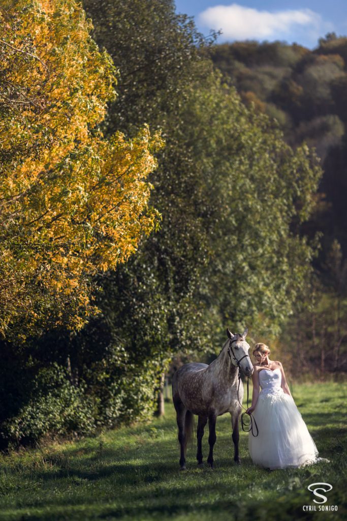 Mariée avec son cheval réalisant une séance de portrait fineart par le photographe de mariage Cyril Sonigo