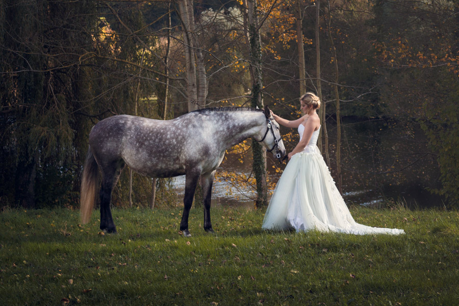 Mariée avec son cheval réalisant une séance de portrait fineart par le photographe de mariage Cyril Sonigo