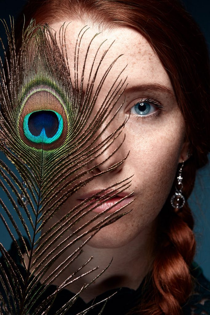 Portrait avec plume de paon modèle rousse par photographe Paris Cyril Sonigo